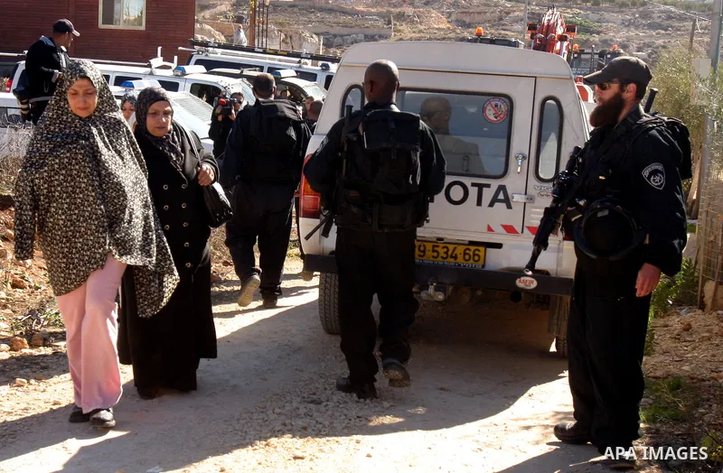 Israeli forces stand guard as a bulldozer destroy a Palestinian family house in an area of the east Jerusalem neighborhood of Beit Hanina which falls in the West Bank side of Israel's separation barrier on Dec. 5, 2011....