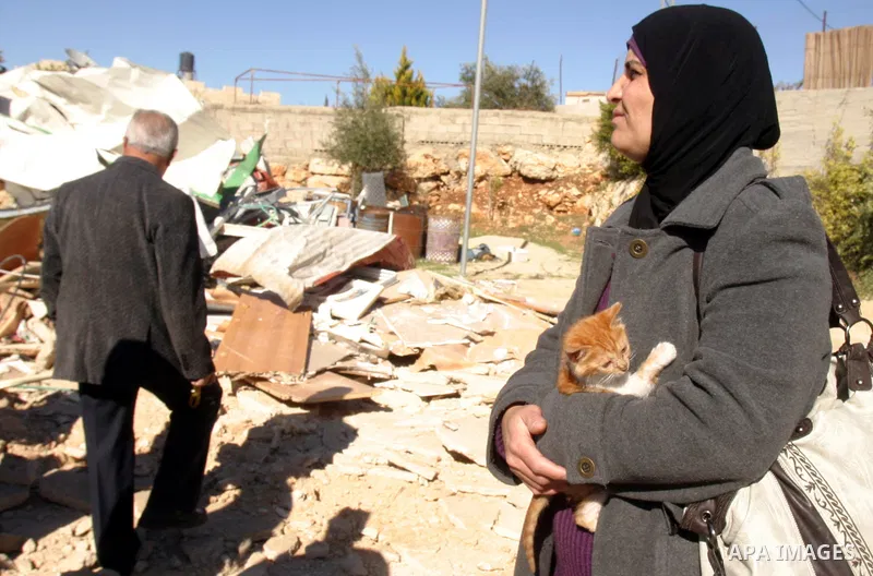 A Palestinian woman reacts after Israeli forces destroyed her family house in an area of the east Jerusalem neighborhood of Beit Hanina which falls in the West Bank side of Israel's separation barrier on Dec. 5, 2011. Ac...