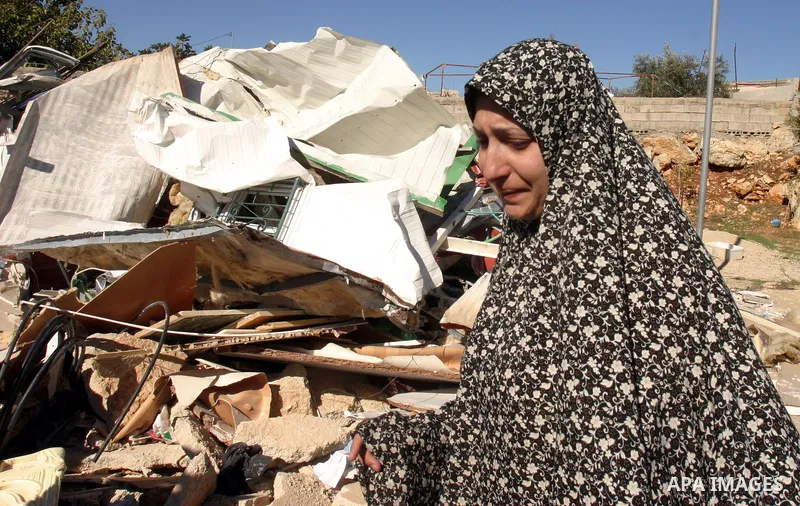 A Palestinian woman reacts after Israeli forces destroyed her family house in an area of the east Jerusalem neighborhood of Beit Hanina which falls in the West Bank side of Israel's separation barrier on Dec. 5, 2011. Ac...