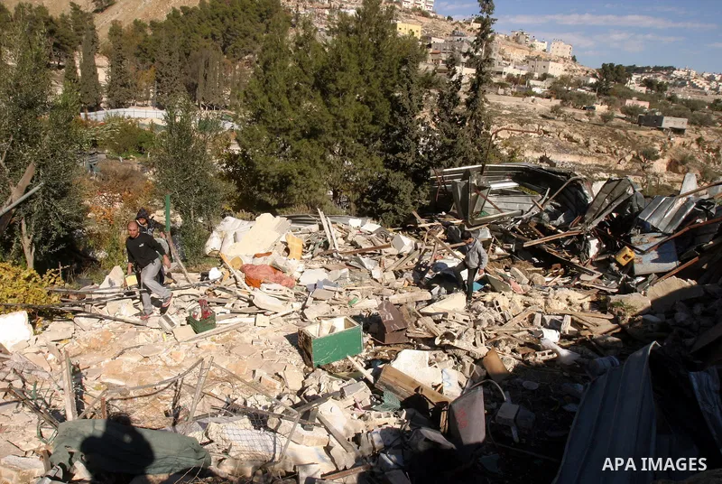 Palestinians inspect their belongings after Israeli forces destroyed their family house in an area of the east Jerusalem neighborhood of Silwan on Dec. 5, 2011. According to Israeli Authorities the house was built withou...