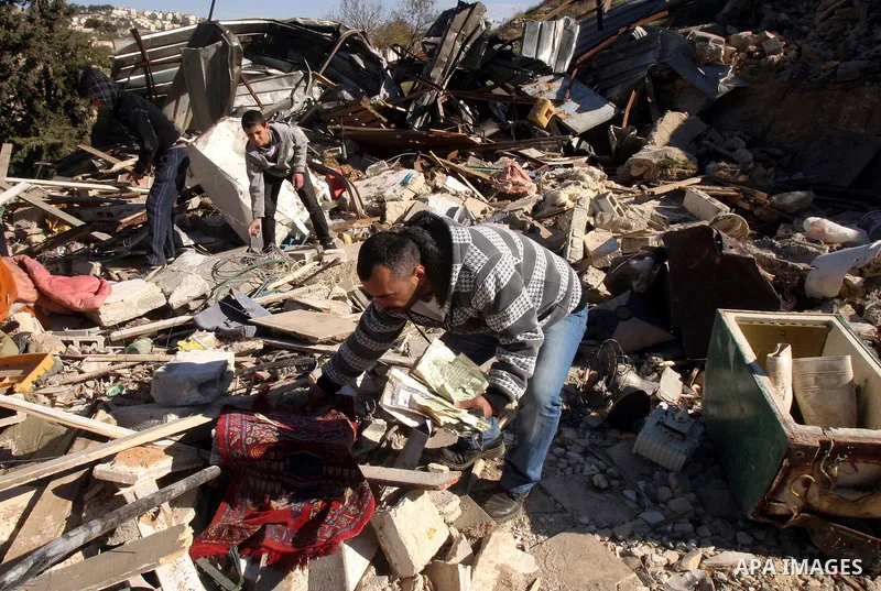 Palestinians inspect their belongings after Israeli forces destroyed their family house in an area of the east Jerusalem neighborhood of Silwan on Dec. 5, 2011. According to Israeli Authorities the house was built withou...