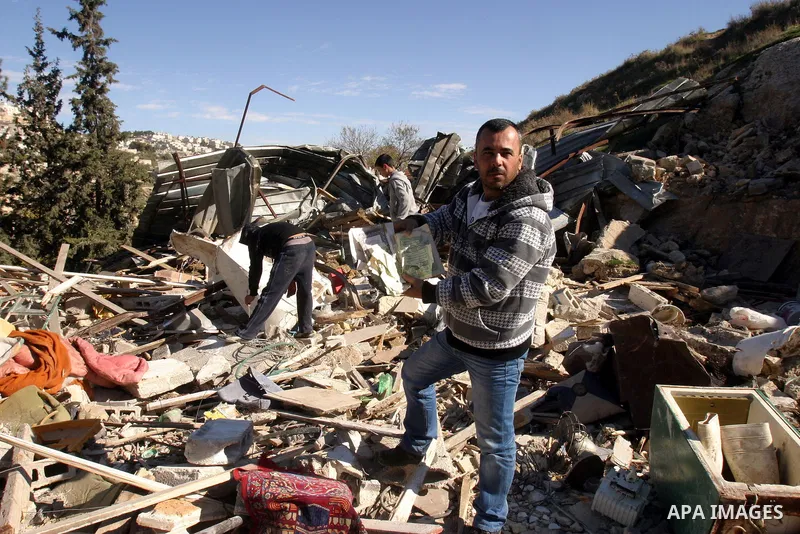 Palestinians inspect their belongings after Israeli forces destroyed their family house in an area of the east Jerusalem neighborhood of Silwan on Dec. 5, 2011. According to Israeli Authorities the house was built withou...