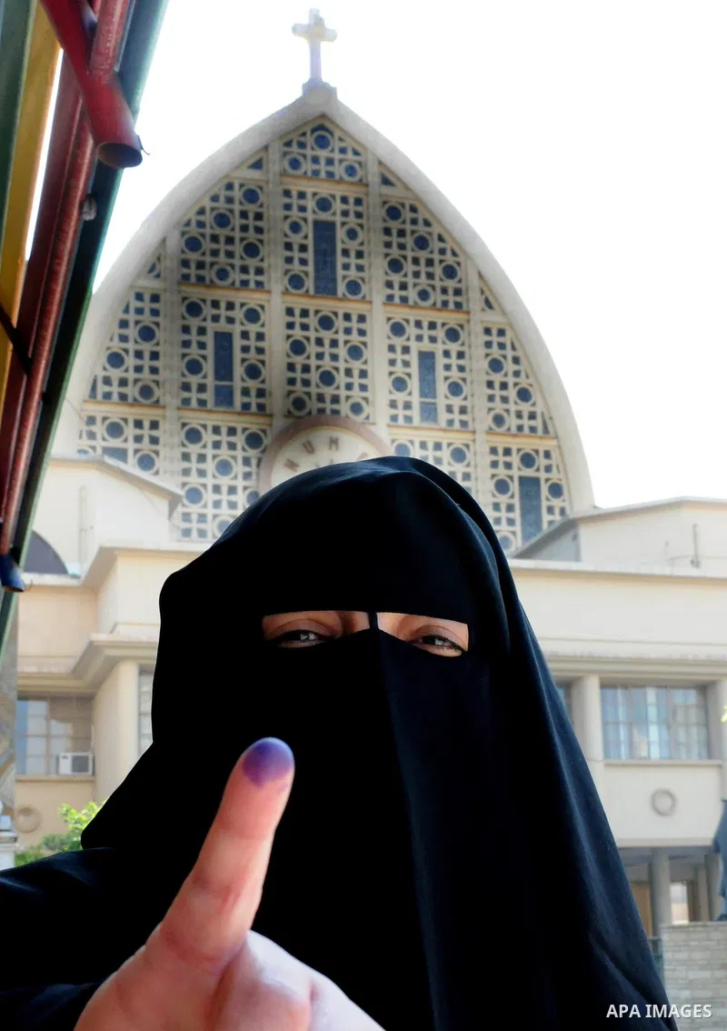 Egyptians cast their ballot at a parliamentary polling station in the run-off of the first round of voting in the Cairo neighbourhood of Bab El-Shaeria on December 5, 2011. Islamist candidates in Egypt looked to extend t...
