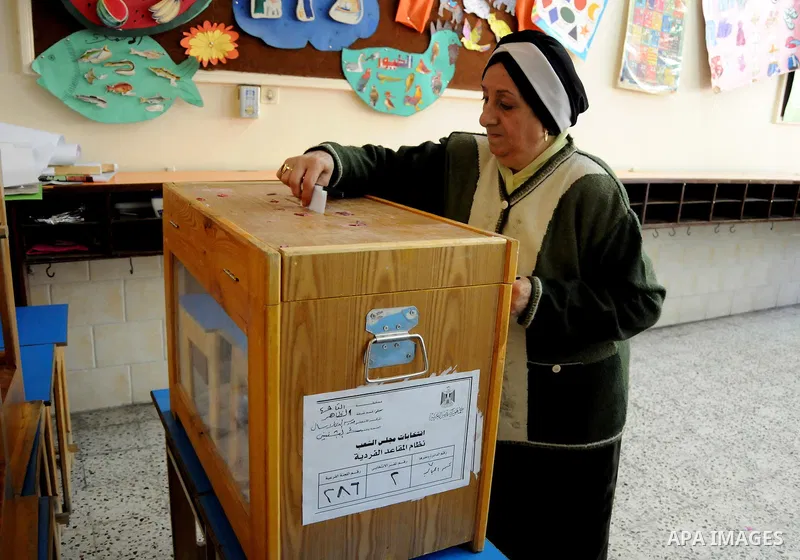 Egyptians cast their ballot at a parliamentary polling station in the run-off of the first round of voting in the Cairo neighbourhood of Bab El-Shaeria on December 5, 2011. Islamist candidates in Egypt looked to extend t...