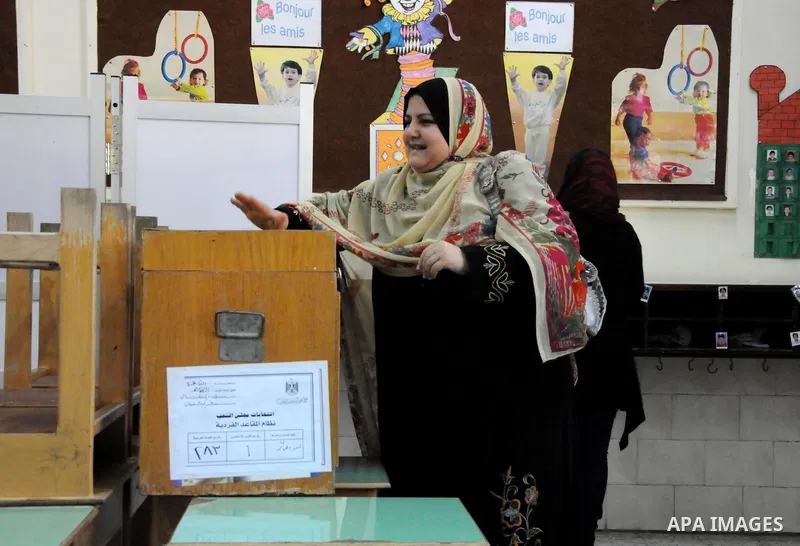 Egyptians cast their ballot at a parliamentary polling station in the run-off of the first round of voting in the Cairo neighbourhood of Bab El-Shaeria on December 5, 2011. Islamist candidates in Egypt looked to extend t...