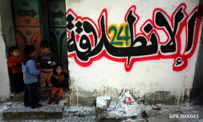 Palestinian children stand outside their home as Palestinian Hamas supporters gather at the Hamas founder home, Ahmed Yaseen to announce the starting of the launch of celebrations marking the 24th anniversary of the Isla...
