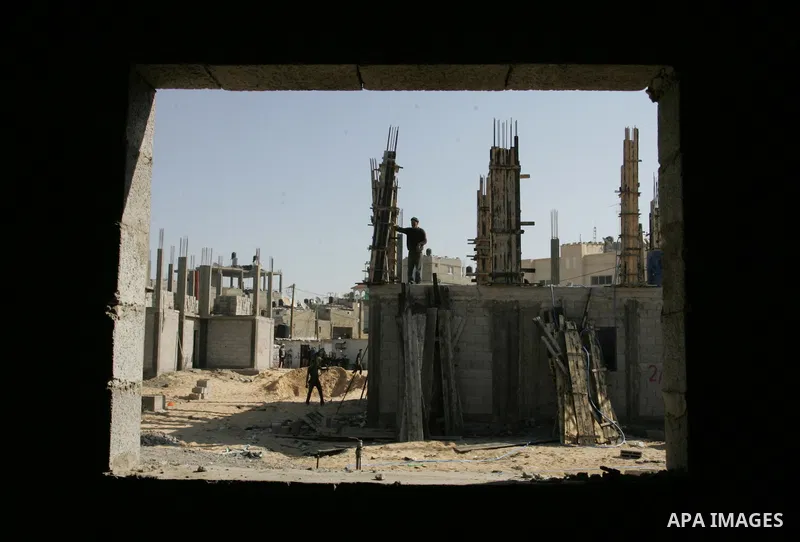 Palestinian laborours work to construct new houses in a project funded by the United Nations Relief and Works Agency for Palestine Refugees (UNRWA) in Rafah, in the southern of Gaza Strip on December 5, 2011. Israel main...