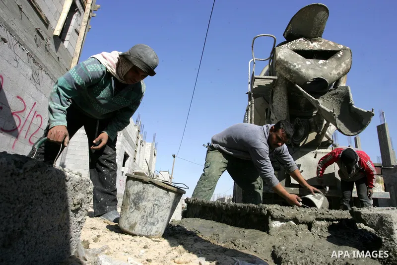 Palestinian laborours work to construct new houses in a project funded by the United Nations Relief and Works Agency for Palestine Refugees (UNRWA) in Rafah, in the southern of Gaza Strip on December 5, 2011. Israel main...