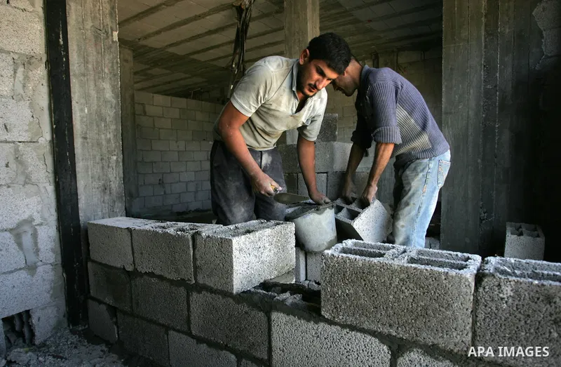 Palestinian laborours work to construct new houses in a project funded by the United Nations Relief and Works Agency for Palestine Refugees (UNRWA) in Rafah, in the southern of Gaza Strip on December 5, 2011. Israel main...