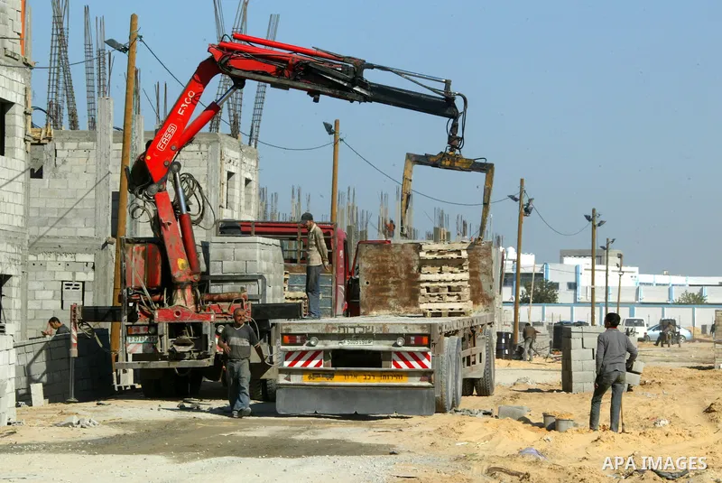 Palestinian laborours work to construct new houses in a project funded by the United Nations Relief and Works Agency for Palestine Refugees (UNRWA) in Rafah, in the southern of Gaza Strip on December 5, 2011. Israel main...