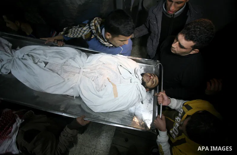 Palestinians people mourn around the body of Islamic Jihad militant Ismail al-Areer who was killed in an Israeli air strike in Gaza City, Gaza, on 07 December 2011. Photo by Mhmoud Nassar