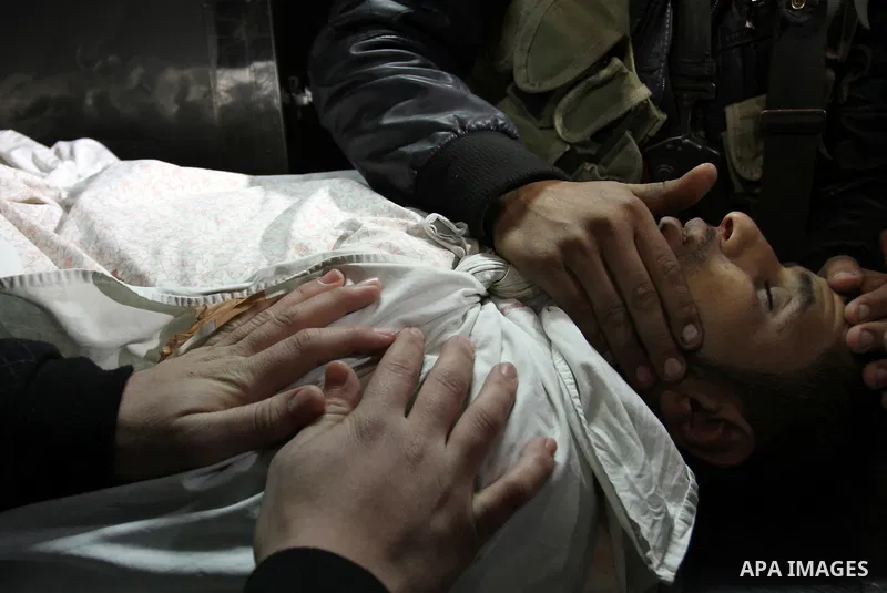 Palestinians people mourn around the body of Islamic Jihad militant Ismail al-Areer who was killed in an Israeli air strike in Gaza City, Gaza, on 07 December 2011. Photo by Mhmoud Nassar