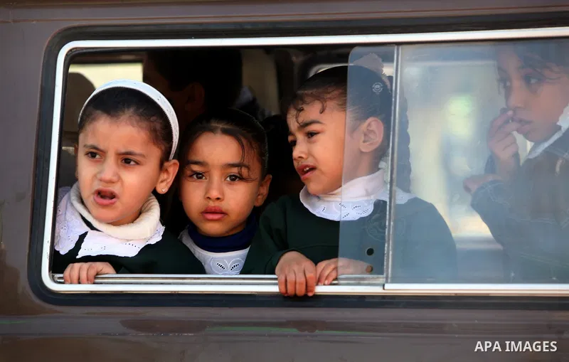 palestinian schoolgirls look from their bus window during the funeral of Islamic Jihad gunman Ismail Al-Areer in Gaza City December 7, 2011. A Palestinian was killed and five others were wounded by Israeli air strikes on...