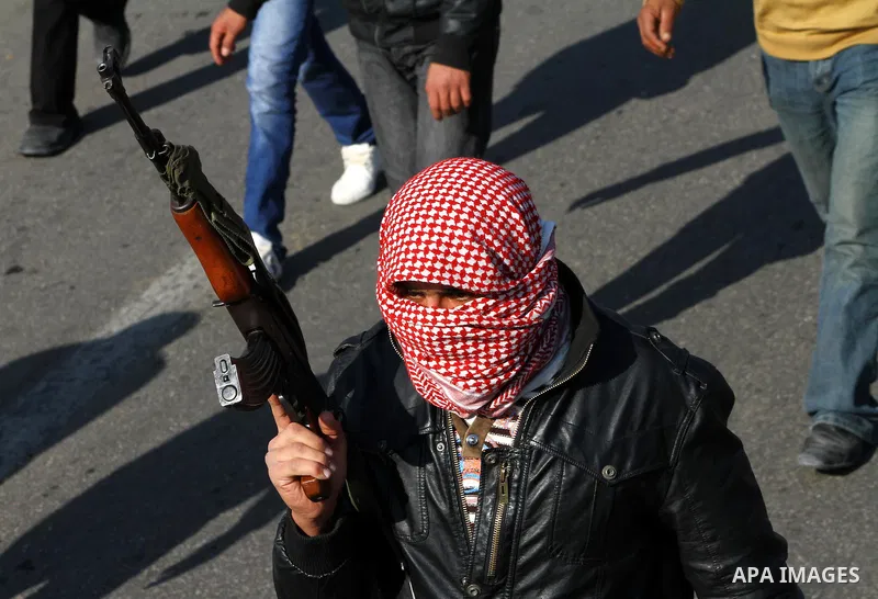 A Palestinian man shots fire in the air during the funeral of Islamic Jihad gunman Ismail Al-Areer in Gaza City December 7, 2011. A Palestinian was killed and five others were wounded by Israeli air strikes on the Gaza S...