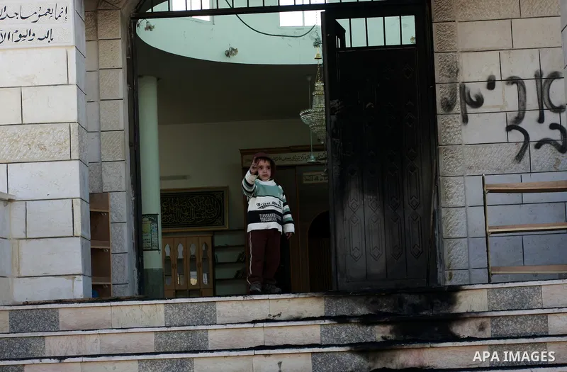 Palestinians stand outside a vandalized mosque where graffiti reading In Hebrew. was sprayed at the entrance of the mosque , in the West Bank Village of Brukin near Nablus, Wednesday , Dec. 07, 2011. Assailants vandalize...