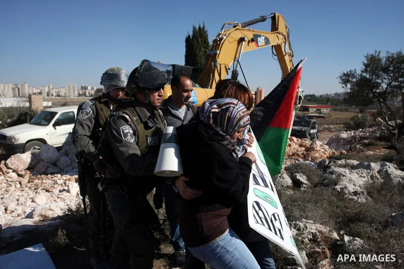 Israeli border police officers scuffle with protesters after they tried to block a construction vehicle from working on Israel's barrier in the West Bank village of Qalandiya near Ramallah December 7, 2011. According to...