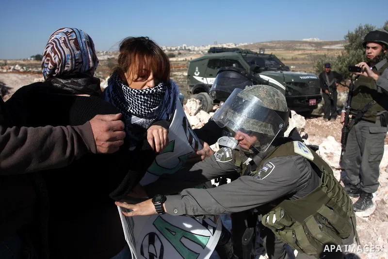 Israeli border police officers scuffle with protesters after they tried to block a construction vehicle from working on Israel's barrier in the West Bank village of Qalandiya near Ramallah December 7, 2011. According to...