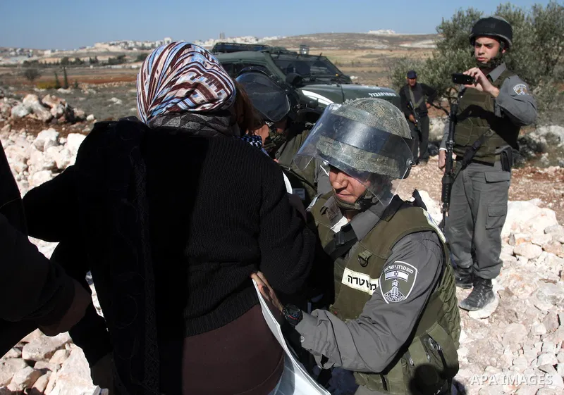 Israeli border police officers scuffle with protesters after they tried to block a construction vehicle from working on Israel's barrier in the West Bank village of Qalandiya near Ramallah December 7, 2011. According to...