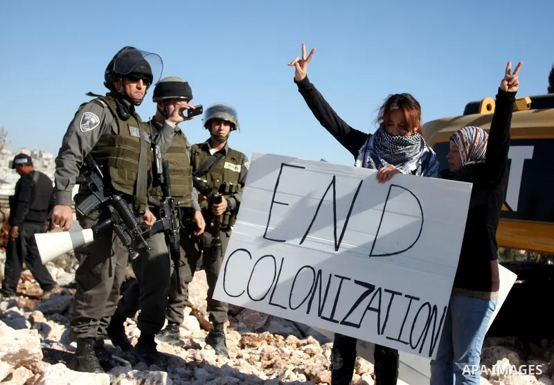 Israeli border police officers scuffle with protesters after they tried to block a construction vehicle from working on Israel's barrier in the West Bank village of Qalandiya near Ramallah December 7, 2011. According to...