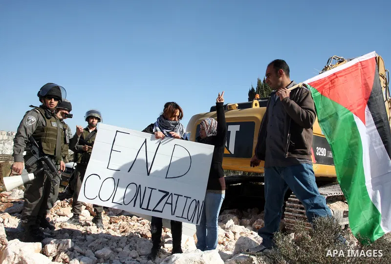 Israeli border police officers scuffle with protesters after they tried to block a construction vehicle from working on Israel's barrier in the West Bank village of Qalandiya near Ramallah December 7, 2011. According to...