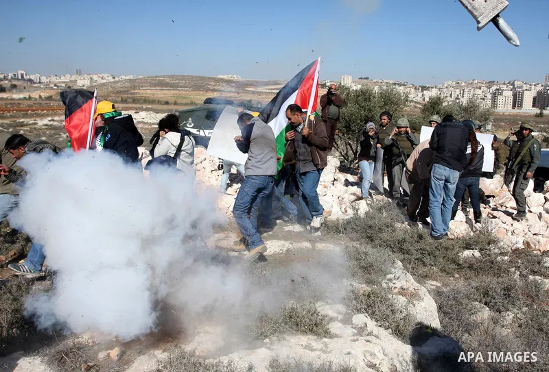 Israeli border police officers scuffle with protesters after they tried to block a construction vehicle from working on Israel's barrier in the West Bank village of Qalandiya near Ramallah December 7, 2011. According to...