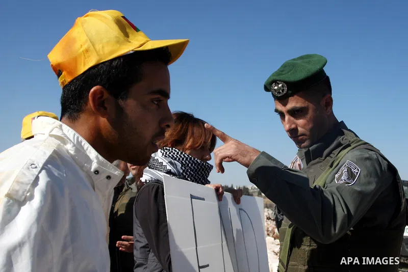 Israeli border police officers scuffle with protesters after they tried to block a construction vehicle from working on Israel's barrier in the West Bank village of Qalandiya near Ramallah December 7, 2011. According to...