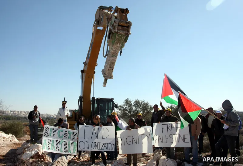 Israeli border police officers scuffle with protesters after they tried to block a construction vehicle from working on Israel's barrier in the West Bank village of Qalandiya near Ramallah December 7, 2011. According to...