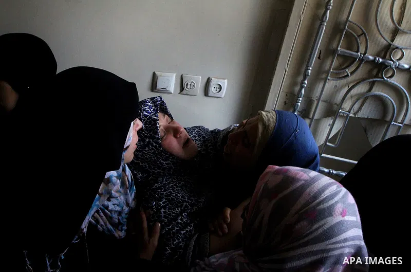 Relative of Palestinians Sobhi al-Batsh, a member of Hamas's armed wing the Ezzedine al-Qassam Brigades, and Issam al-Batsh, a senior member of the Al-Aqsa Martyrs Brigades, mourn at his home during his funeral in Gaza C...