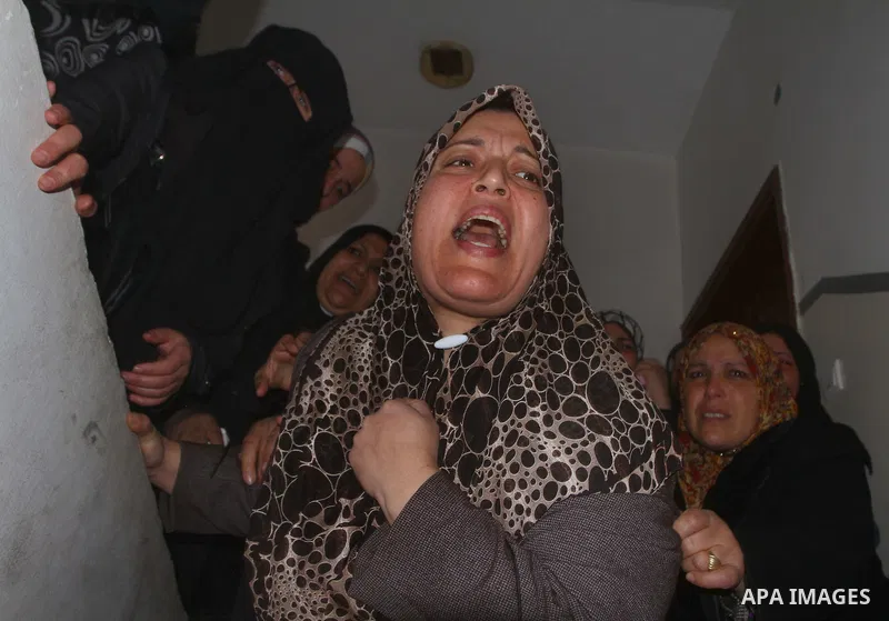Relative of Palestinians Sobhi al-Batsh, a member of Hamas's armed wing the Ezzedine al-Qassam Brigades, and Issam al-Batsh, a senior member of the Al-Aqsa Martyrs Brigades, mourn at his home during his funeral in Gaza C...