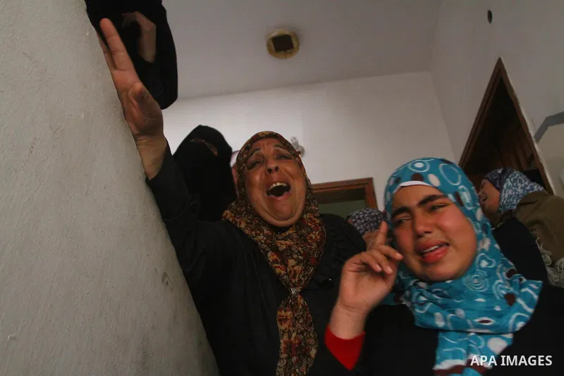 Relative of Palestinians Sobhi al-Batsh, a member of Hamas's armed wing the Ezzedine al-Qassam Brigades, and Issam al-Batsh, a senior member of the Al-Aqsa Martyrs Brigades, mourn at his home during his funeral in Gaza C...