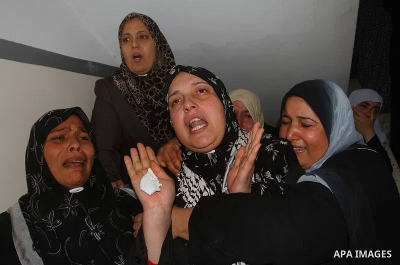 Relative of Palestinians Sobhi al-Batsh, a member of Hamas's armed wing the Ezzedine al-Qassam Brigades, and Issam al-Batsh, a senior member of the Al-Aqsa Martyrs Brigades, mourn at his home during his funeral in Gaza C...