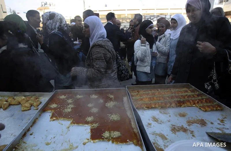 Palestinian bakers prepare a giant Kunafa, a favorite local sweet, during a celebration in the West Bank city of Nablus, Thursday, Dec. 8, 2011. Photo by Wagdi Eshtayah.