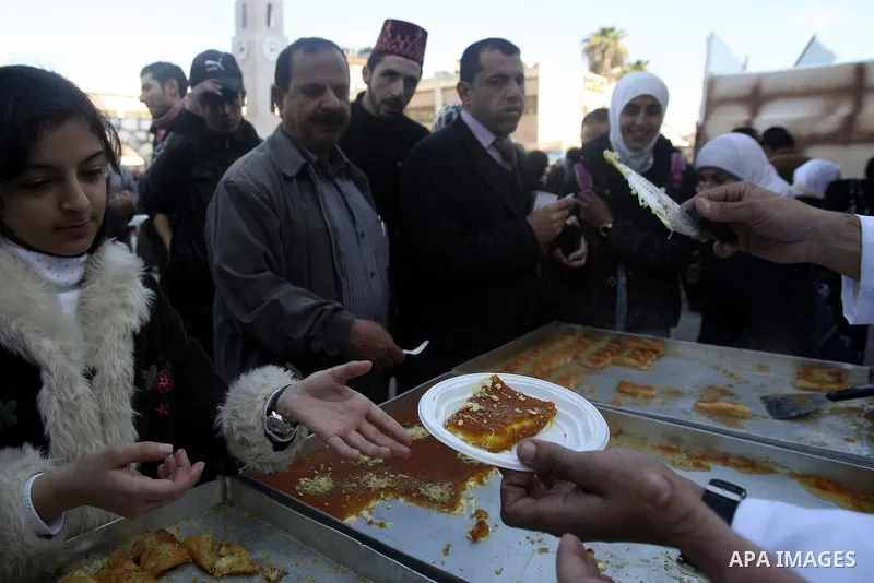 Palestinian bakers prepare a giant Kunafa, a favorite local sweet, during a celebration in the West Bank city of Nablus, Thursday, Dec. 8, 2011. Photo by Wagdi Eshtayah.