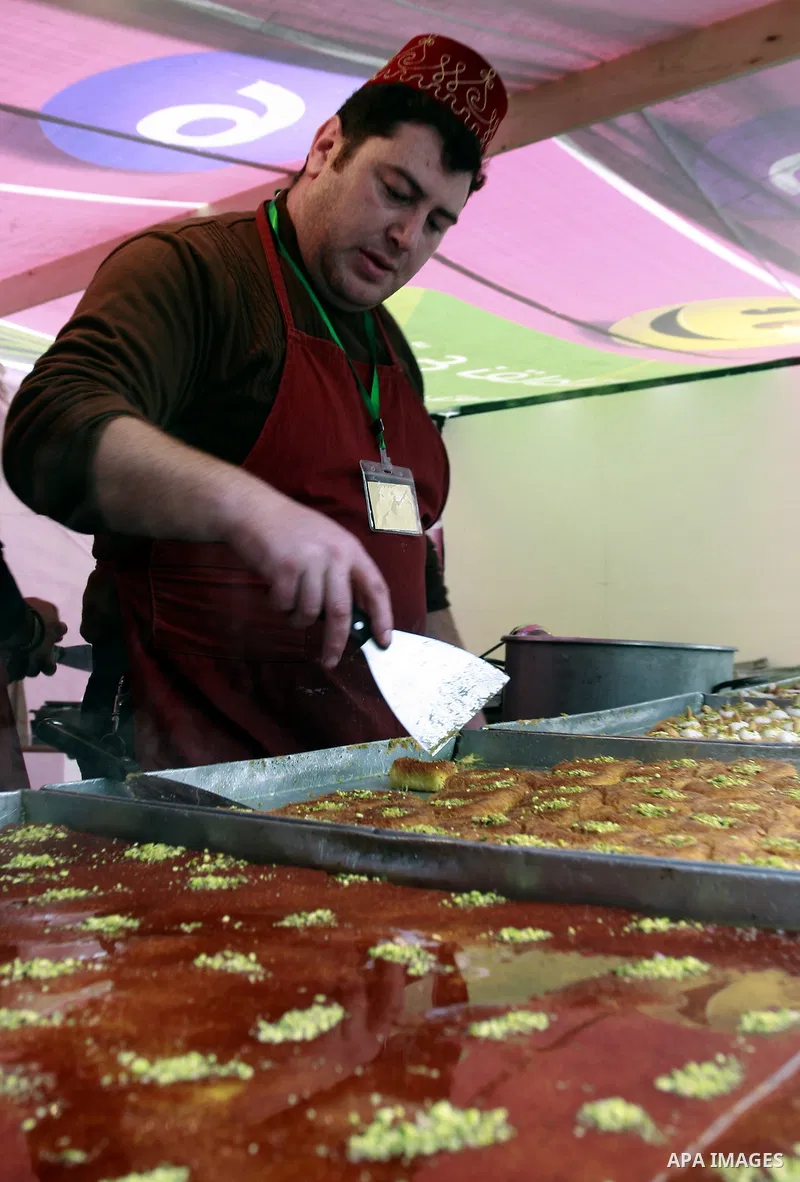 Palestinian bakers prepare a giant Kunafa, a favorite local sweet, during a celebration in the West Bank city of Nablus, Thursday, Dec. 8, 2011. Photo by Wagdi Eshtayah.