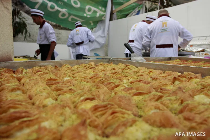Palestinian bakers prepare a giant Kunafa, a favorite local sweet, during a celebration in the West Bank city of Nablus, Thursday, Dec. 8, 2011. Photo by Wagdi Eshtayah.