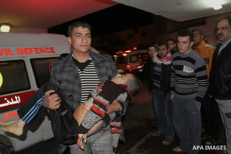 Palestinian men wheel a wounded boy on a stretcher into al-Shifa hospital in Gaza City on 09 December 2011. An Israeli air strike killed at least one Palestinian and wounded others, Palestinian medical and security sourc...