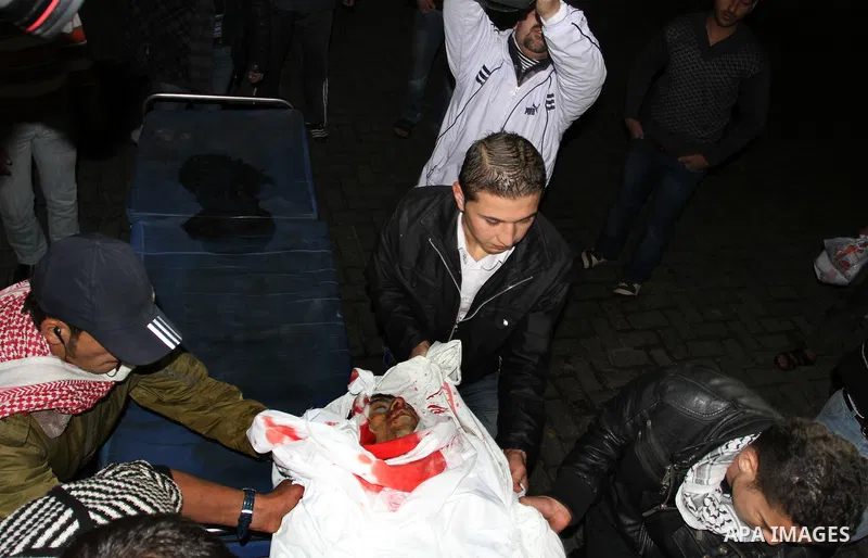 Palestinian men wheel a wounded man on a stretcher into al-Shifa hospital in Gaza City on December 9, 2011, after an Israeli air strike. Photo by Mahmud Nassar