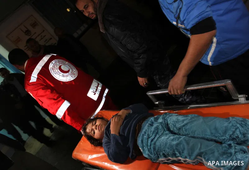 Palestinian men wheel a wounded boy on a stretcher into al-Shifa hospital in Gaza City on 09 December 2011. An Israeli air strike killed at least one Palestinian and wounded others, Palestinian medical and security sourc...