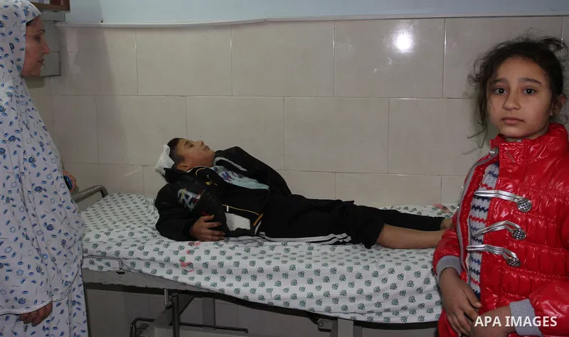 Palestinian medical workers wheel a wounded boy on a stretcher into al-Shifa hospital in Gaza City on December 9, 2011, after an Israeli air strike. Photo by Mahmud Nassar