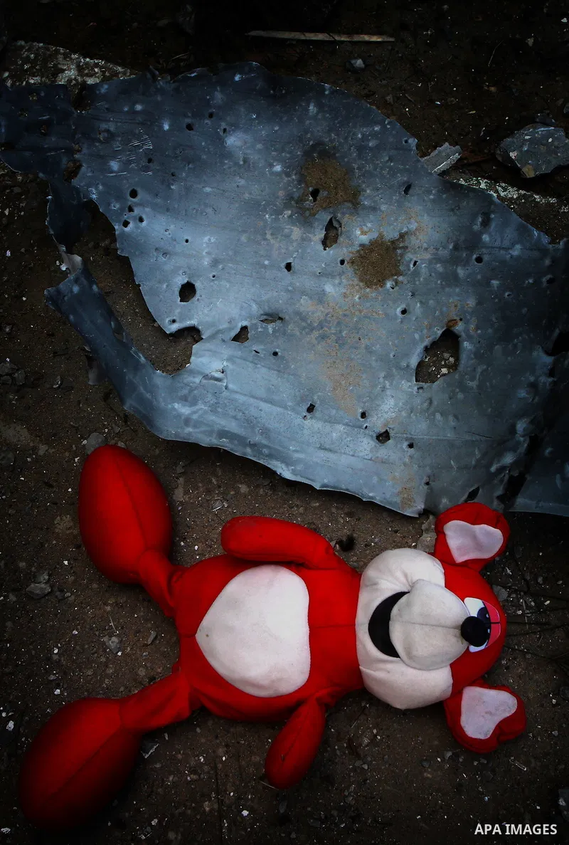 A Palestinian man holds toys as he looks at a house damaged in an Israeli air strike in Gaza City, on December 9, 2011. Violence across the Israeli-Gaza border escalated on Friday with Israeli air strikes killing at leas...