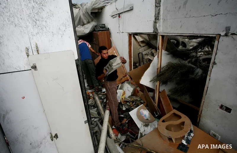 Palestinians inspect a destroyed house in Gaza city on December 9, 2011. Violence across the Israeli-Gaza border escalated on Friday with Israeli air strikes killing at least three people and Palestinian militants firing...