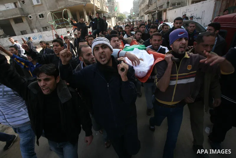 Palestinians carry the body of Bahjat Al-Zalan, who was killed in a blast from an Israeli air strike on a nearby Hamas training camp in Gaza City, during his funeral in Gaza City December 9, 2011. Violence across the Isr...