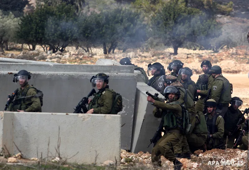 Israeli soldiers fire tear gas at Palestinian demonstrators during a protest against the construction of Israel's separation barrier in the West Bank village of Qalandia, near Ramallah, on December 9, 2011. Photo by Issa...