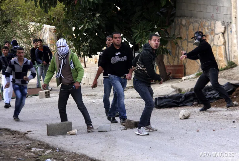Palestinian protesters throw stones towards Israeli soldiers during clashes that broke out at a weekly demonstration against Israeli-occupation in the northern West Bank village of Kfar Kadum on December 9, 2011. A Pales...