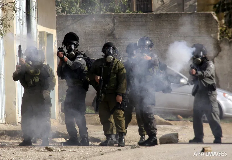 Israeli soldiers fire tear gas towards Palestinian protesters during clashes that broke out at a weekly demonstration against Israeli-occupation in the northern West Bank village of Kfar Kadum on December 9, 2011. A Pale...