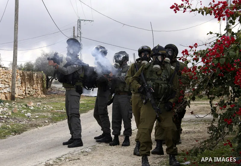 Israeli soldiers fire tear gas towards Palestinian protesters during clashes that broke out at a weekly demonstration against Israeli-occupation in the northern West Bank village of Kfar Kadum on December 9, 2011. A Pale...