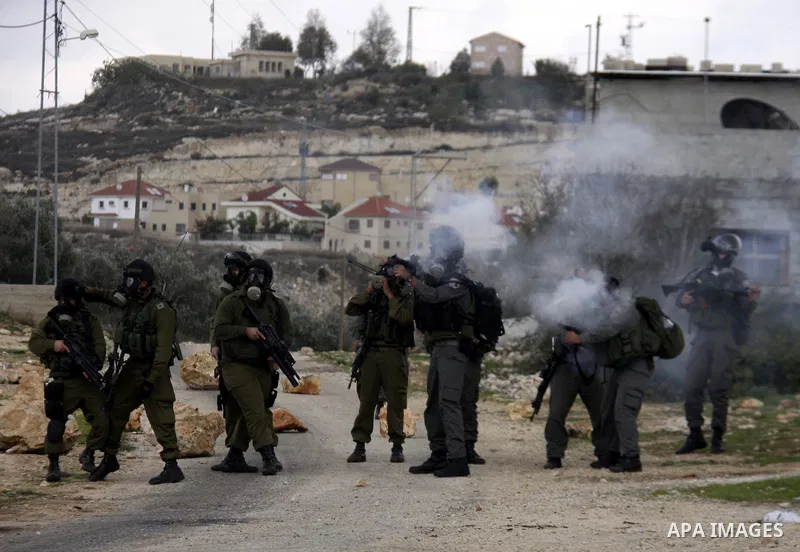 Israeli soldiers fire tear gas towards Palestinian protesters during clashes that broke out at a weekly demonstration against Israeli-occupation in the northern West Bank village of Kfar Kadum on December 9, 2011. A Pale...