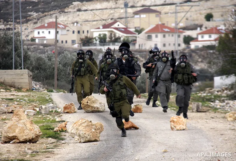 Israeli soldiers fire tear gas towards Palestinian protesters during clashes that broke out at a weekly demonstration against Israeli-occupation in the northern West Bank village of Kfar Kadum on December 9, 2011. A Pale...