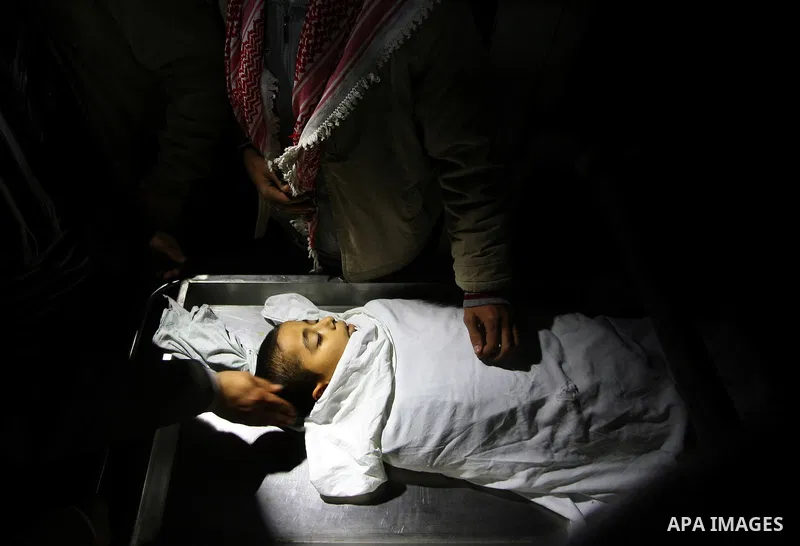 The body of Ramadan al-Zalan, 12, is seen inside the mourgue at al-Shifa hospital in Gaza City on December 9, 201. Al-Zalan was killed after an Israeli air strike. Photo by Mahmud Nassar