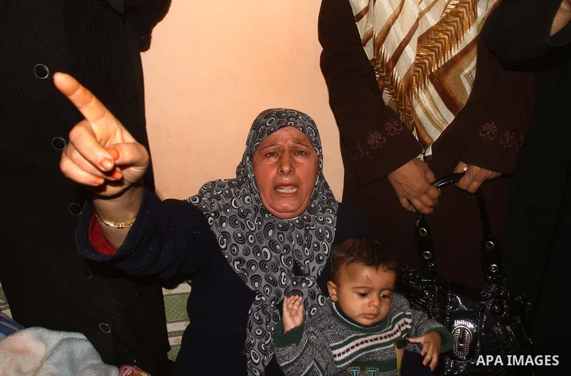 Relatives mourn during the funeral of Palestinian boy Ramadan Al-Zalan, who was killed in a blast from an Israeli air strike on a nearby Hamas training camp, in Gaza City December 10, 2011. Violence has flared up between...